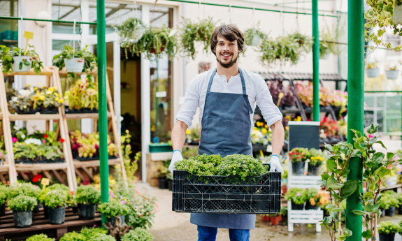 Man holding plants at a plant nursery 